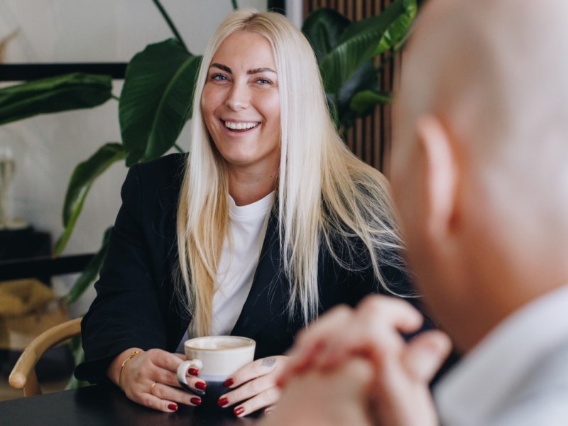 blonde vrouw met lange haren aan een tafel