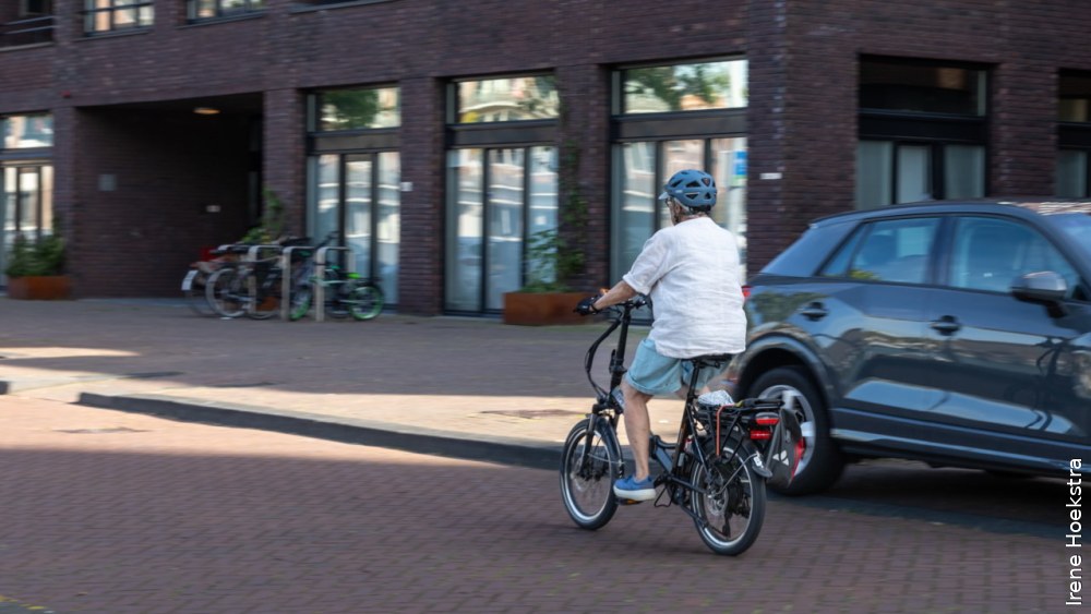 Ouder persoon op de fiets in een straat